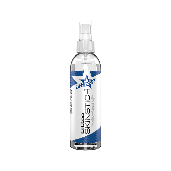 Le flacon pulvérisateur « UNISTAR Tattoo Skinstich 240 ml » présente des éléments graphiques bleus et blancs, une buse de pulvérisation et un texte pour l’utilisation en tatouage, sur fond blanc.